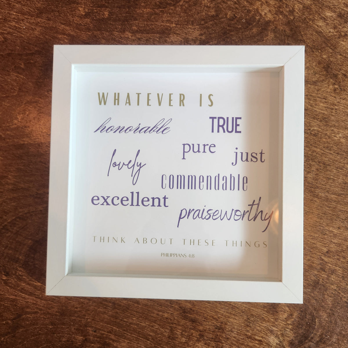 A white square framed typographic wall art print with motivational words such as 'honorable,' 'true,' 'pure,' 'just,' 'commendable,' 'excellent,' and 'praiseworthy'.